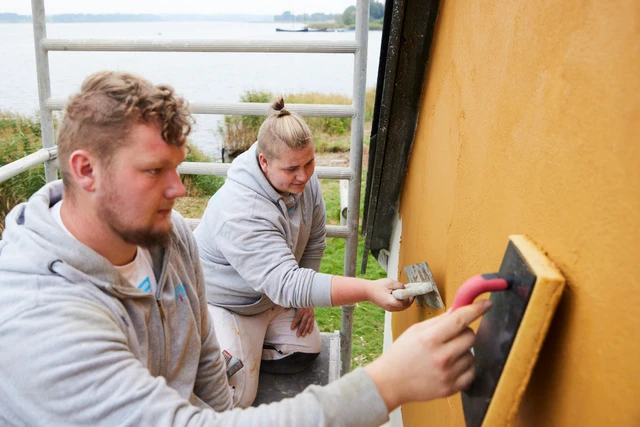 To håndværkere arbejder sammen på et byggeprojekt